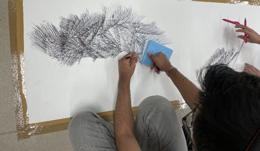 Man sketching lines on a large piece of paper